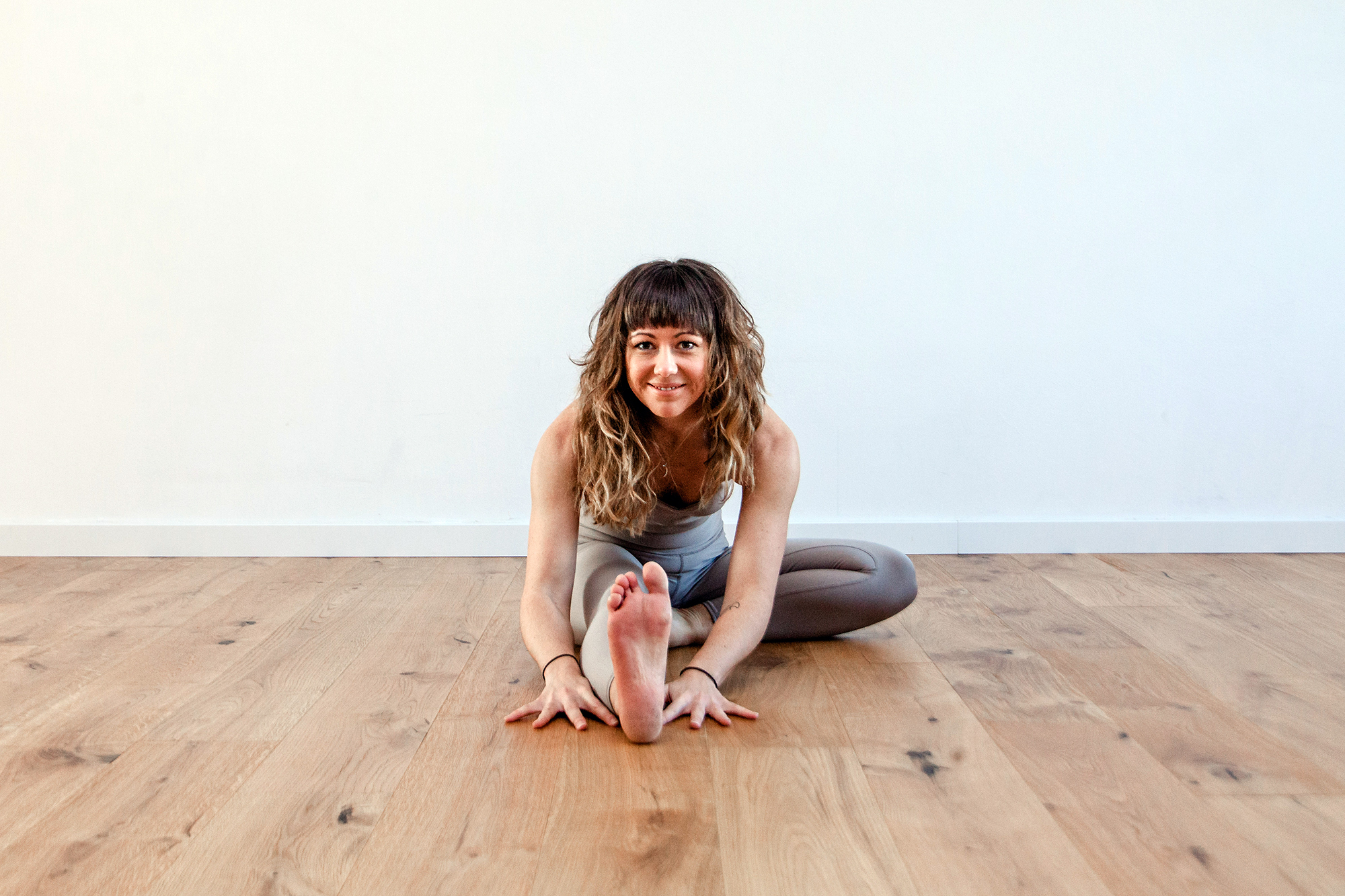 Frau sitzt am Boden in Yogaposition