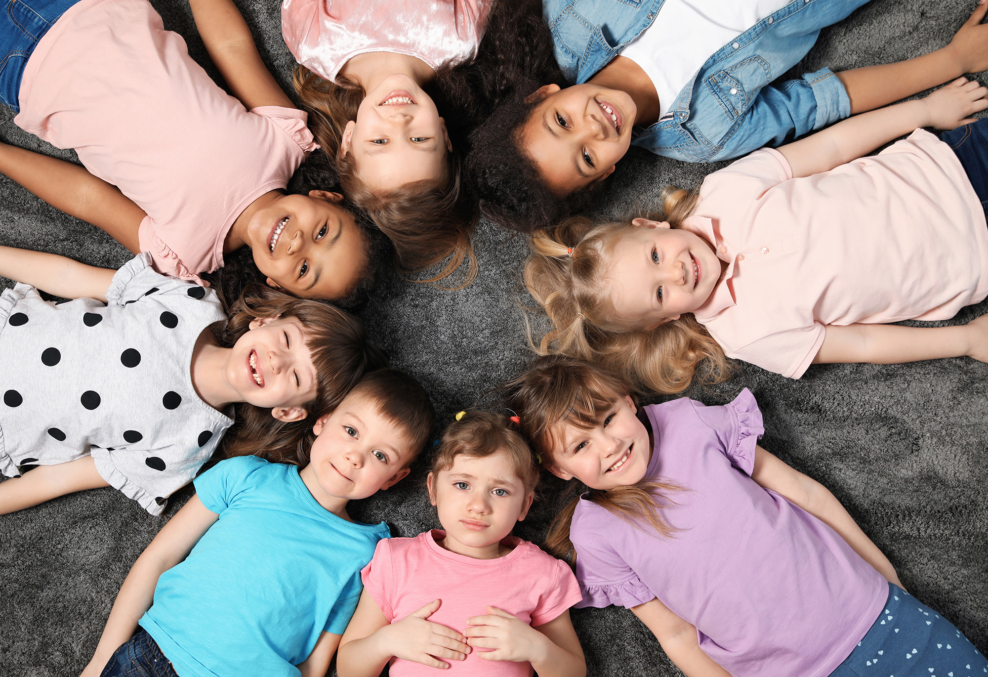 viele Kinder liegen am Boden Kopf an Kopf